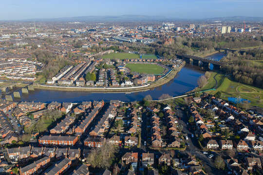 A morning aerial shot showcasing the River Ribble loop, modern flood defenses, and the urban skyline of Preston, Lancashire.