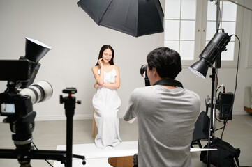 スタジオで女性モデルを撮影する男性カメラマン