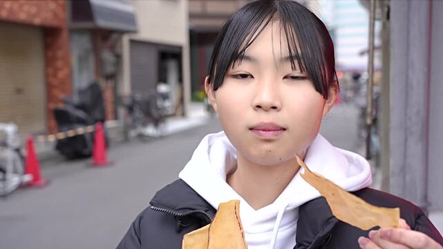 浅草で食べ歩きをする10代の女性