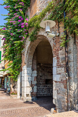 Fototapeta premium Streets of Sirmione in Lombardy, where colorful buildings and quaint shops invite visitors to experience Italian culture firsthand. Enjoy the bright atmosphere.