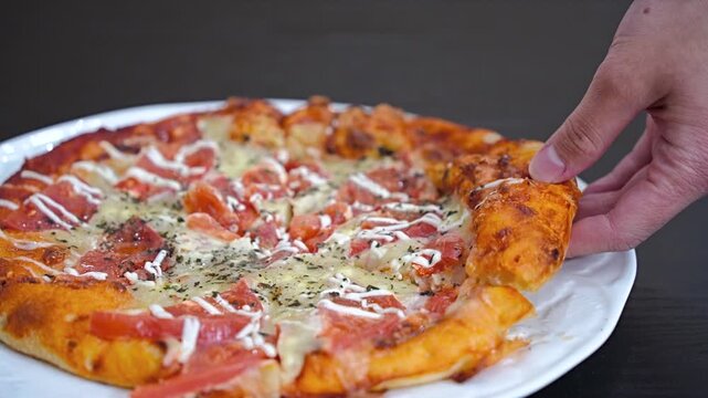 トマトいっぱいピザをもつ女性の手元