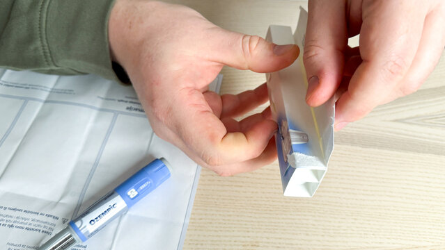 A Caucasian male's hands unveil a mysterious parcel, akin to Pandora's urban wellness, resonating with Cyber Monday's cryptic promises Ozempic, GLP 1, Semaglutide, January 5 2026, Subotica, Serbia