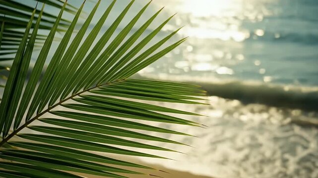 A vibrant green palm frond gracefully extends across the foreground, framing a stunning view of a sun-drenched tropical seascape. Golden light reflects and shimmers on the gentle waves of the ocean, c