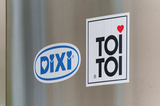 TOI TOI and DIXI Group logo displayed on a metal stand nearby the entrance to the office building