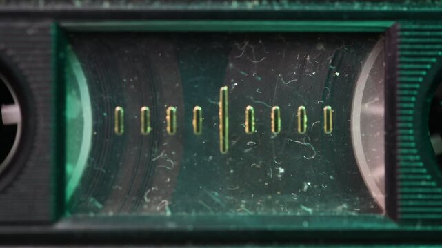 Close up of audio cassette in old cassette player with dust and light.