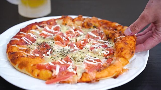 トマトいっぱいピザをもつ男性の手元と生ビール