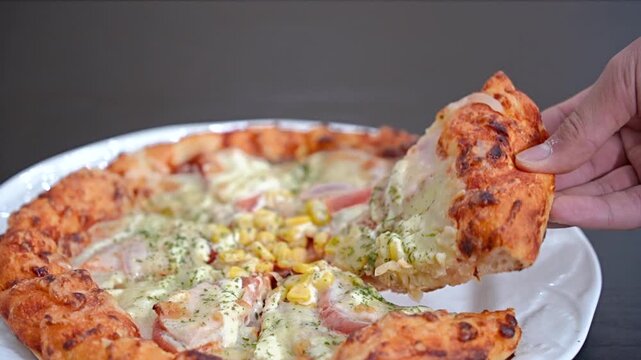 ベーコントマトピザをもつ男性の手元