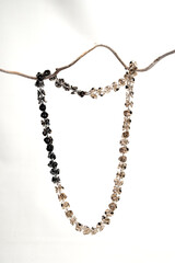 Fototapeta premium Black and white beaded necklaces on a branch