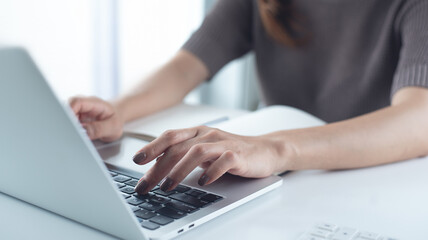 Close up, woman hand typing on laptop computer keyboard. Business woman online working on laptop...