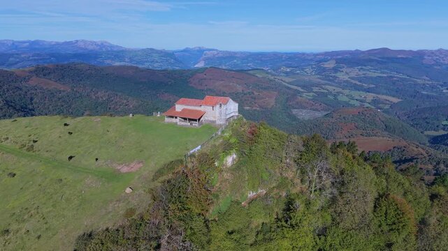 Aerial view from a drone of Mount Coliza (897 m) (Kolitza in Basque) with the chapel of San Sebasti&aacute;n and San Roque in the Ordunte Mountains in Valmaseda. Bizkaia, Basque Country, Spain.