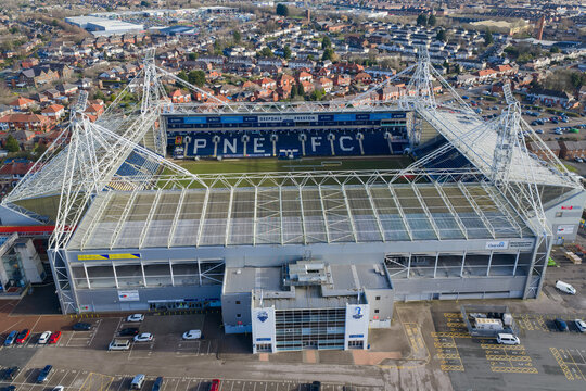 Aerial image of Deepdale Stadium in Preston, showcasing the modern steel support structures of the Sir Tom Finney Stand and the surrounding urban landscape.