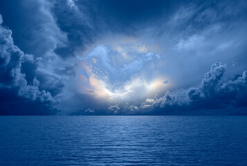Night sky with full moon in the clouds and reflection in the sea - Deep blue moonlit 
