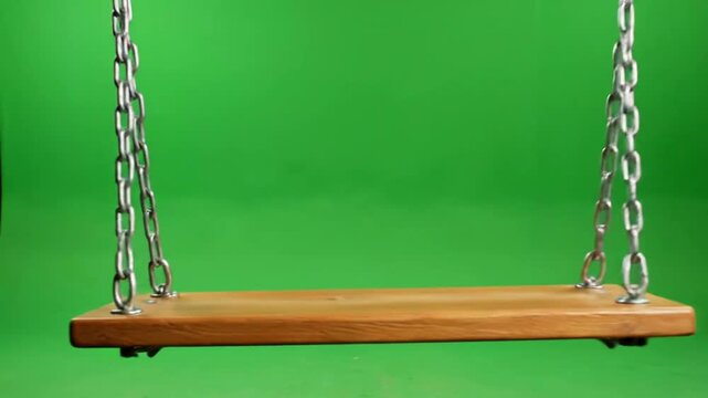 Wooden swing hanging on chains with green screen background