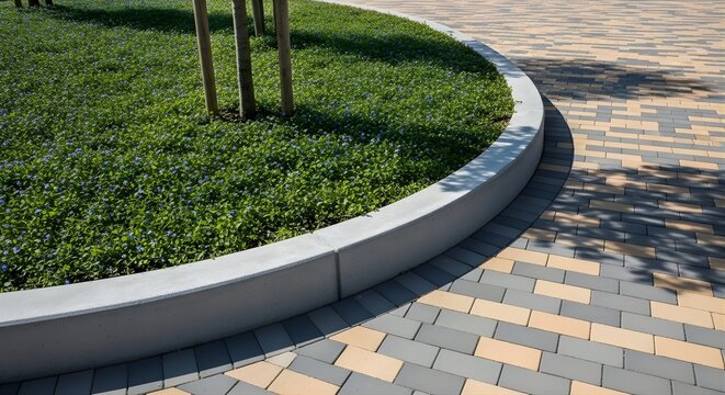 Curved landscape bed with paved walkway featuring interlocking brick pattern and greenery