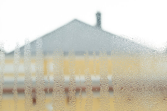 Wet window glass surface with heavy moisture and misted texture.