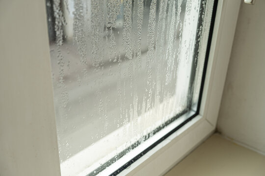 Close up of misted window glass with water streaks and droplets
