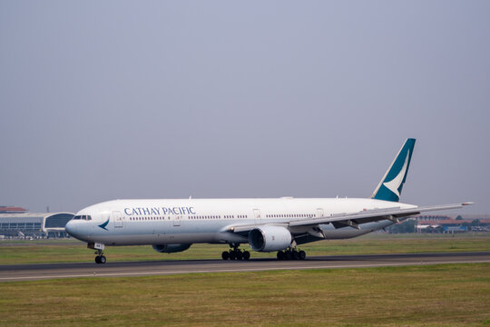 Tangerang, Indonesia - August 11, 2024 : A Cathay Pacific Airbus A330-300 taxis on the runway at Soekarno-Hatta International Airport during a clear day.