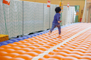 室内遊具で元気に遊ぶ子供の笑顔と成長のイメージ