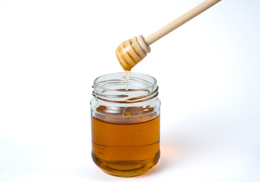  Honey jar with wooden dipper isolated on white