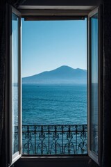 Fototapeta premium View of Mount Vesuvius from a balcony overlooking the water during a clear day with bright sunlight shining on the scene