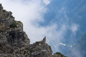 Alpine landscape with rugged peak rising above cloud‑covered valley