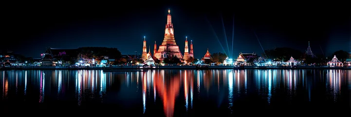Wat Arun temple night panorama with river reflections and illuminated Bangkok skyline, Thailand © YAK XL