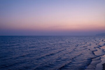 Calm Ocean Waves Under a Soft Pink and Blue Sunset Sky