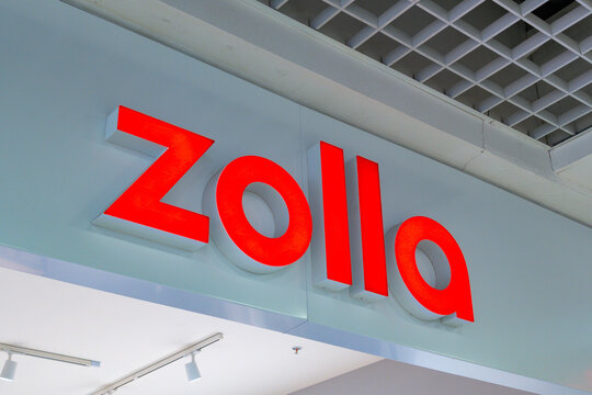Bright red Zolla sign displayed prominently in a modern retail space during daylight hours in a shopping area