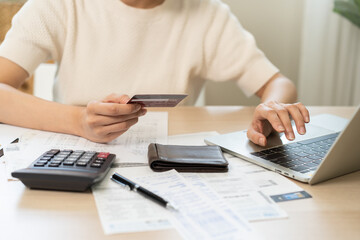 Fototapeta premium Internet banking, Online shopping at home, asian young woman hand in typing on keyboard, holding credit card, using laptop computer, spending money with purchase on store at home. Shopaholic ecommerce