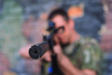 Naklejka premium Ukrainian soldier aiming rifle in urban combat