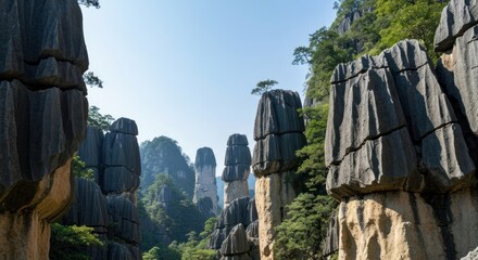 Stone pillars in a valley, sunlight through trees