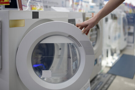 家電量販店で洗濯機を選ぶ女性の手