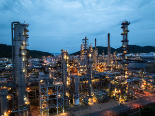 Close up aerial view of distillation towers in oil refinery plant at blue hour for petrochemical engineering industry and chemical manufacturing factory business concept. © SHUTTER DIN