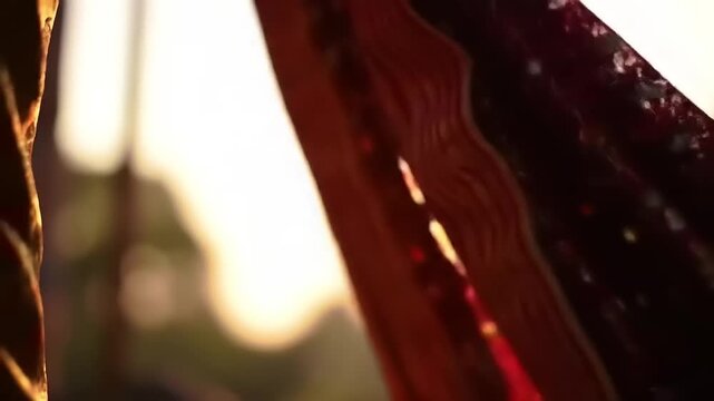 Red fabric detail with floral pattern, and sunlight.