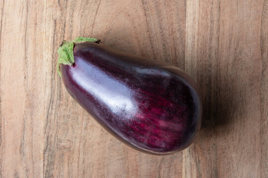 A purple eggplant on a wood background