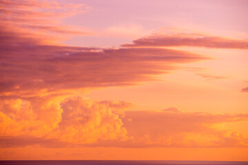 Obraz premium Golden Sunset Over the Sea with Vivid Pink and Orange Clouds
