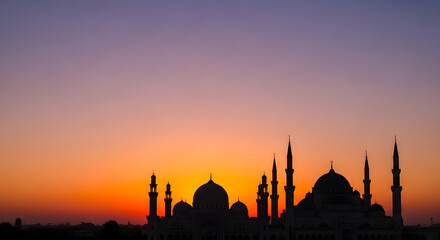 Naklejka premium Beautiful Silhouette of Mosque Minarets Against Vibrant Twilight Sky