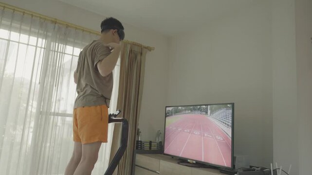 A person engages in an indoor workout session utilizing virtual technology for fitness. The scene captures a blend of exercise and modern tech, showcasing a treadmill alongside a screen displaying a v