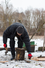 A man is chopping firewood in the yard. Men's work