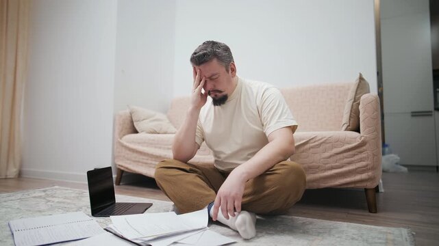 Stressed middle-aged man suffering from a headache at home
