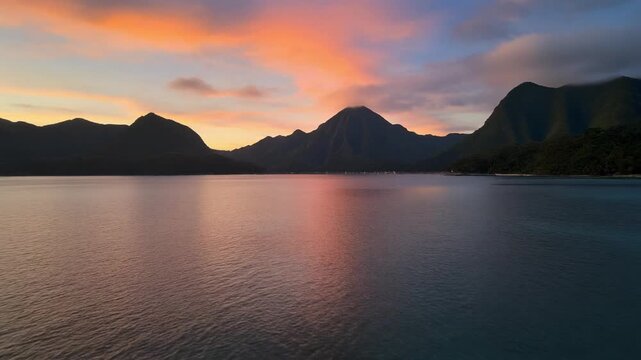 Bora Bora Island: Serene Sunset Reflecting on Calm Ocean Waters with Mountain Backdrop