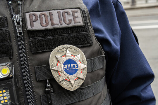 Paris, France - 31 janvier 2026: Insigne "Police Nationale - Agent de Police Judiciaire" et marquage "Police" port&eacute;s sur le gilet tactique de l'uniforme d'un policier fran&ccedil;ais 