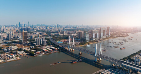 Aerial view of Guangzhou cityscape with bridge crossing pearl river, sunrise