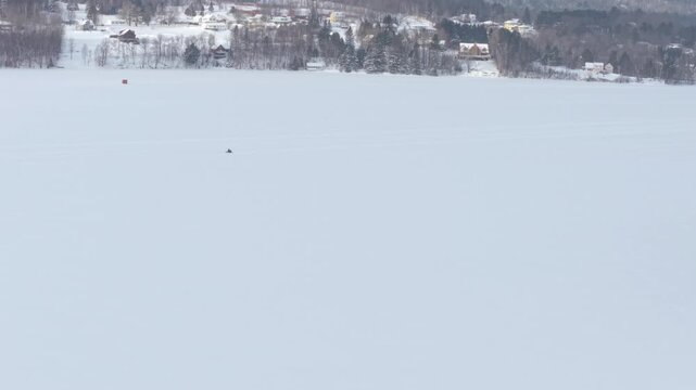 Drone View of Snowmobile Going Across Frozen Lake in Northeast - Vermont, USA 