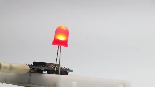 Red color LED blinking that is connected to breadboard and powered by a programmable micro controller