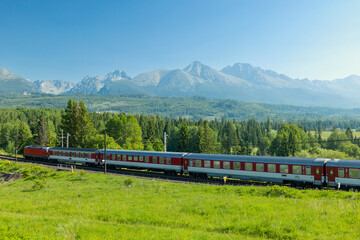 Train traveling across High Tatras mountains landscape in Strba, Slovakia
