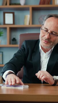 Portrait of dishonest criminal bearded official which taking illegal bribe as euro banknotes and putting them into table from unknown indecent female person ,fraud and machinations in power
