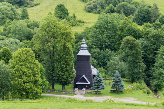Historic wooden church building among green nature in Chyrowa, Poland