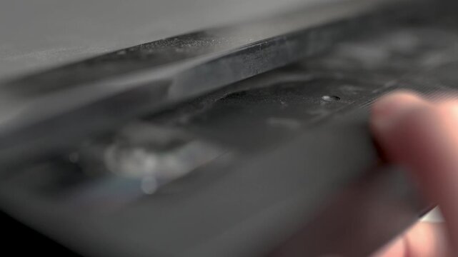 Close up of a hand holding a videotape. Retro vhs cassete in a player.	