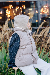 Vertical winter profile portrait of mixed race girl in padded vest outdoors © Iryna